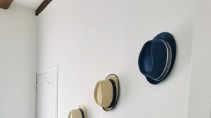 A room with a white wall, a black table, and four hats hanging on the wall. - 1-Dieppe getaway at AndriNormandy, 200m from the beach (Dieppe)