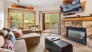 A cozy living room with a fireplace, comfortable seating, and a television.