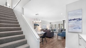 Un interior moderno con una escalera, un comedor y una sala de estar.