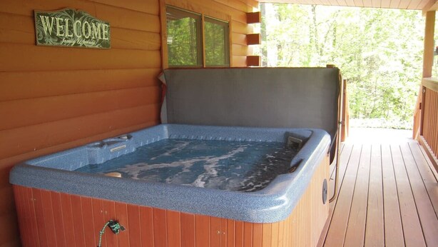 A wooden deck with a hot tub. - Amazing Grace in Shagbark (Pigeon Forge)
