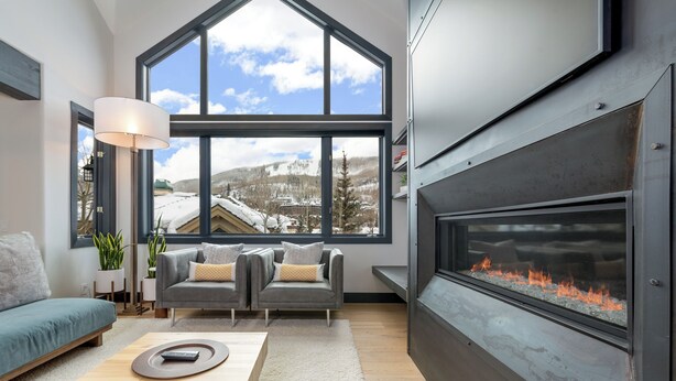 A modern living room with a fireplace, large windows, and a cozy seating area. - Urban Home at The Aspens by InvitedHome | Hike In/Out, Near BC Village, Decks (Avon)