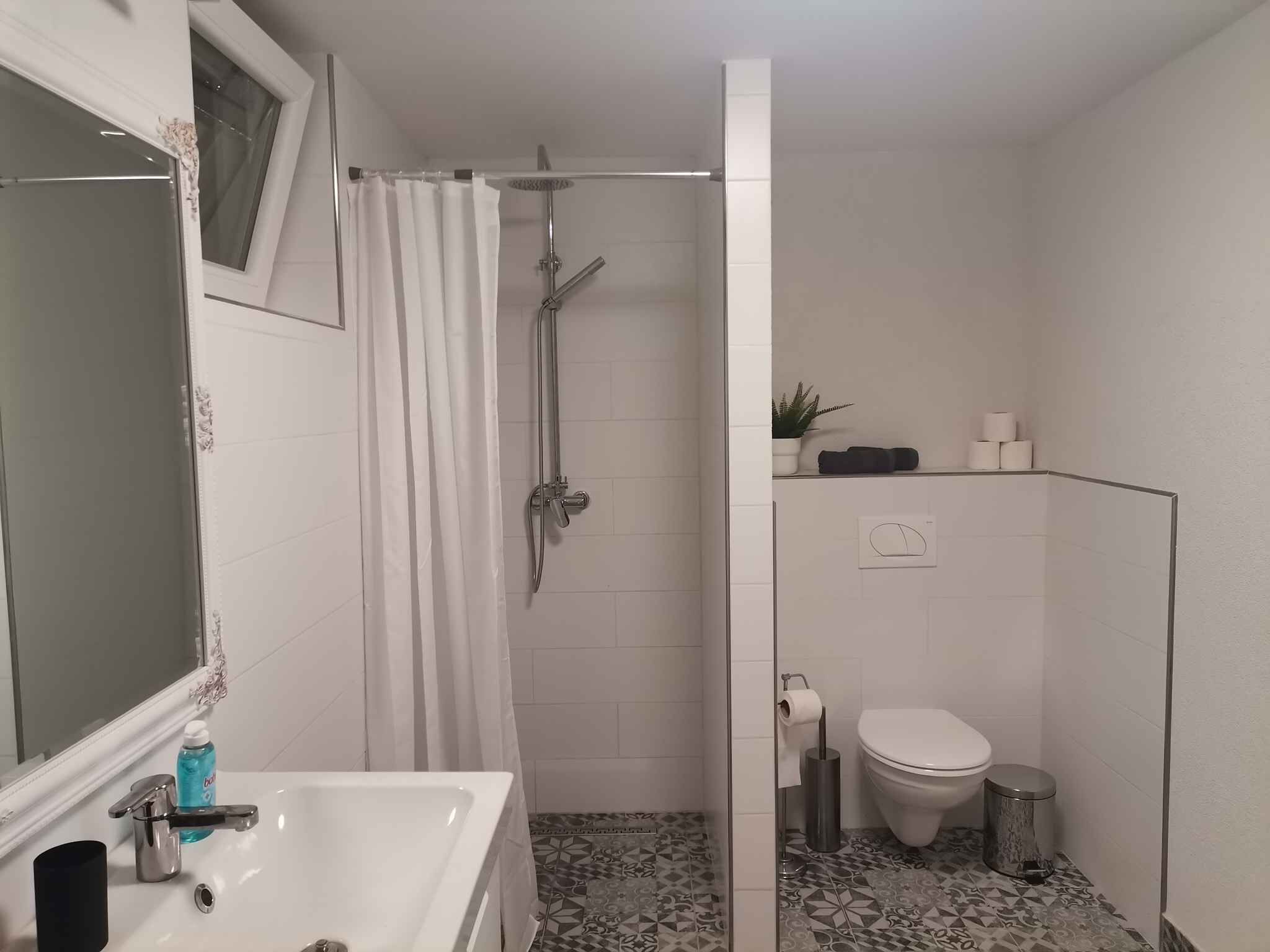 Un baño con ducha, inodoro y lavabo.