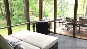 Una habitación con un ventanal grande, un sofá, una mesita y una terraza amoblada.