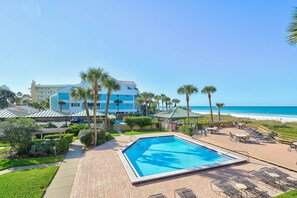 Ein Resort mit Pool, Strandblick und Palmen.