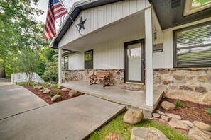 Welcome to this charming home, featuring a cozy porch with a bench and a beautiful garden.