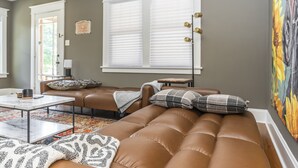 A modern living room with a brown leather sofa, a coffee table, and a patterned rug. - Stylish 2Bed/2Ba home in Chevy Chase, close to Downtown and UK! (Lexington)