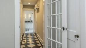 A hallway with a checkered floor leading to a kitchen area. - Stylish 2Bed/2Ba home in Chevy Chase, close to Downtown and UK! (Lexington)