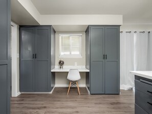 Modern kitchen with a central island, white chair, and ample storage.