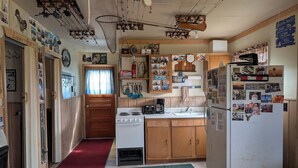 A kitchen with wooden cabinets, a stove, a refrigerator, and various fishing memorabilia.