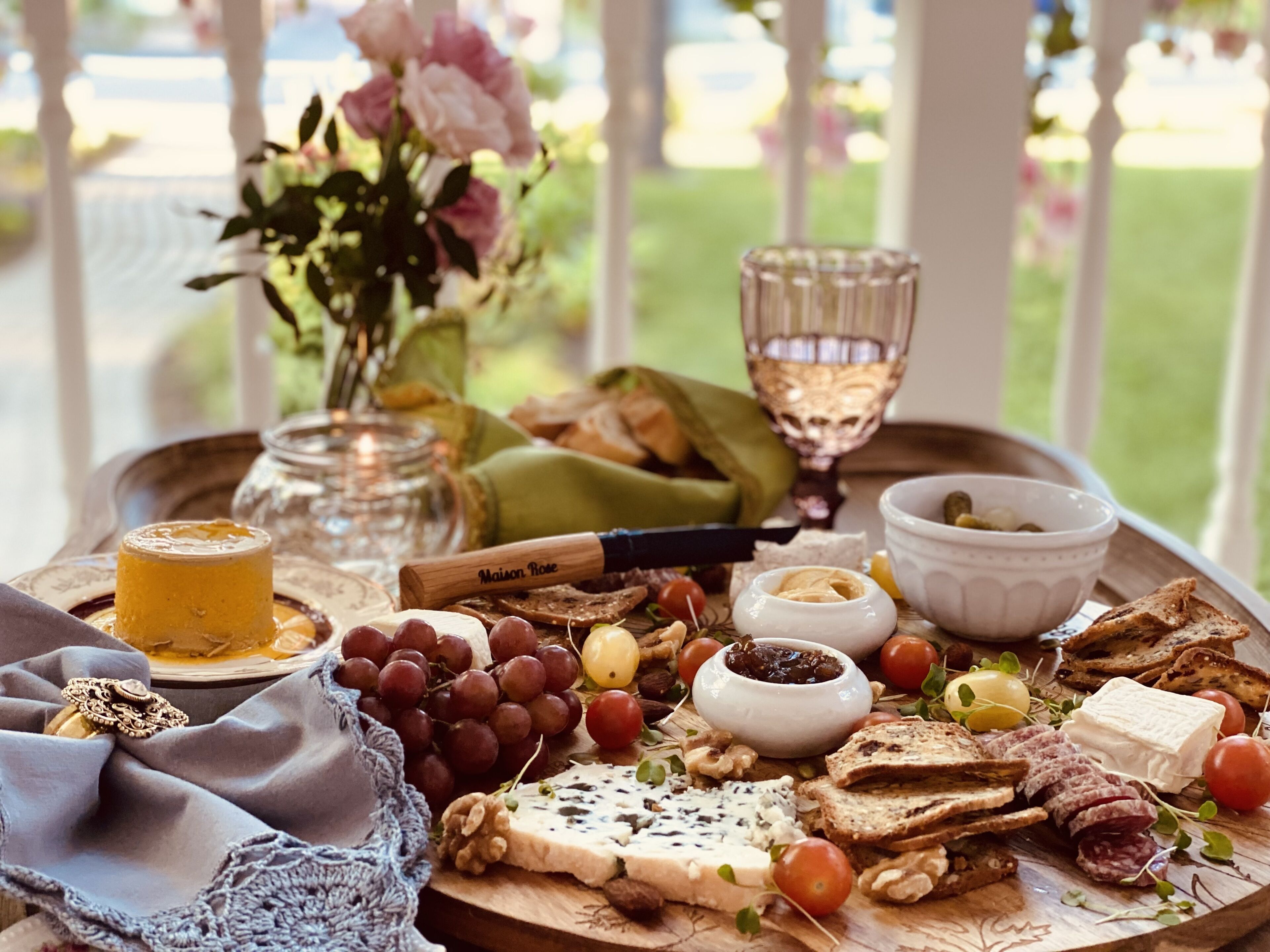 A charcuterie board with various cheeses, fruits, nuts, and bread, arranged on a tray.