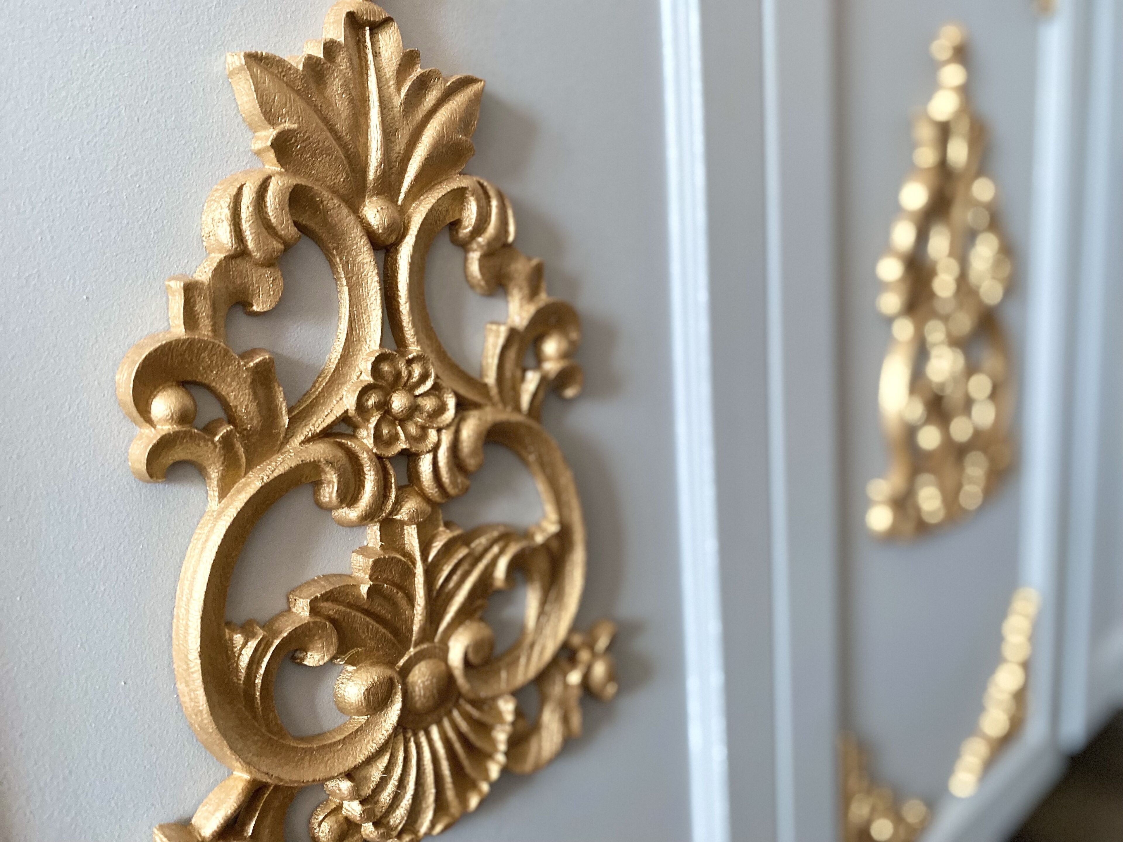 Decoraciones de pared doradas y ornamentales con diseños intrincados.