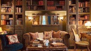A cozy library with a sofa, chairs, and a coffee table. - Maison Rose (Hudson)