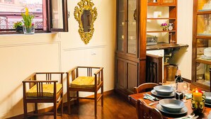 Un comedor con sillas de madera, una mesa dispuesta para dos personas y un candelabro.