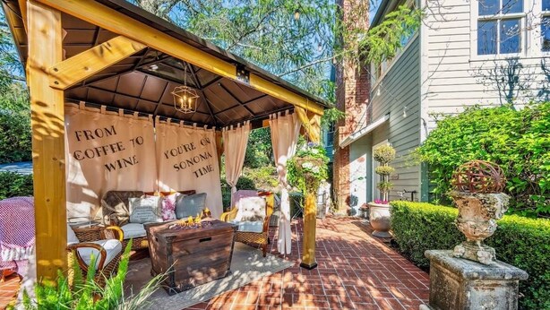 A covered outdoor seating area with a banner reading 'FROM COFFEE TO WINE'.