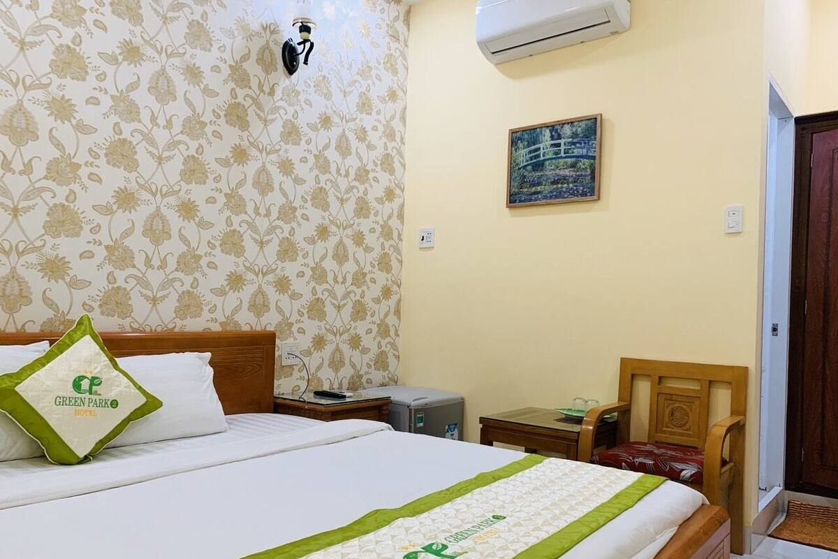 A hotel room with a bed, a nightstand, a desk, and a chair.