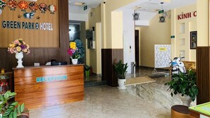 A hotel reception area with a wooden reception desk, a clock, and a sign for the Green Park 2 Hotel. - Green Park 2 Hotel (Quy Nhon Nam)