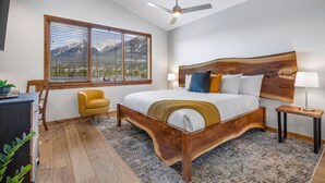 Un dormitorio con cama de madera, un escritorio, una silla, una ventana con persianas y un ventilador de techo.