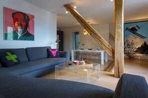 Un salon moderne avec un canapé, une table basse et un tableau accroché au mur.