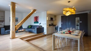 A modern living space with a dining area, kitchen, and staircase. - Le Majestic 145 appt -  sleeps 6 guests in 3 bedrooms, centre Chamonix, parking (Chamonix)