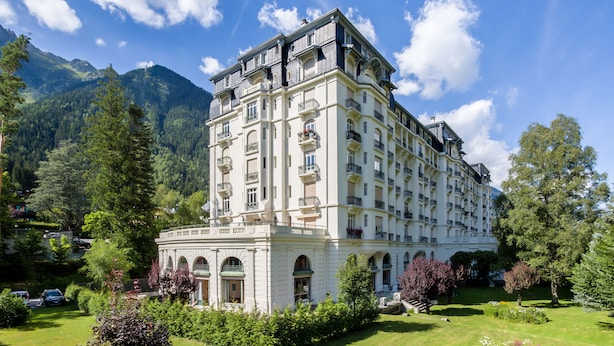 A large, multi-story hotel with a classic architectural style, surrounded by lush greenery and mountains. - Le Majestic 145 appt -  sleeps 6 guests in 3 bedrooms, centre Chamonix, parking (Chamonix)