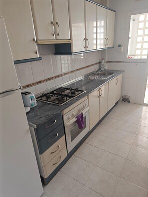 A kitchen with a gas stove, oven, and a sink. - Central 2-Bed Apartment in Estepona Port (Estepona)