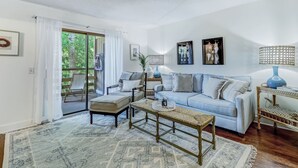 Un salon avec un canapé bleu clair, une table basse en bois et un tapis à motifs.