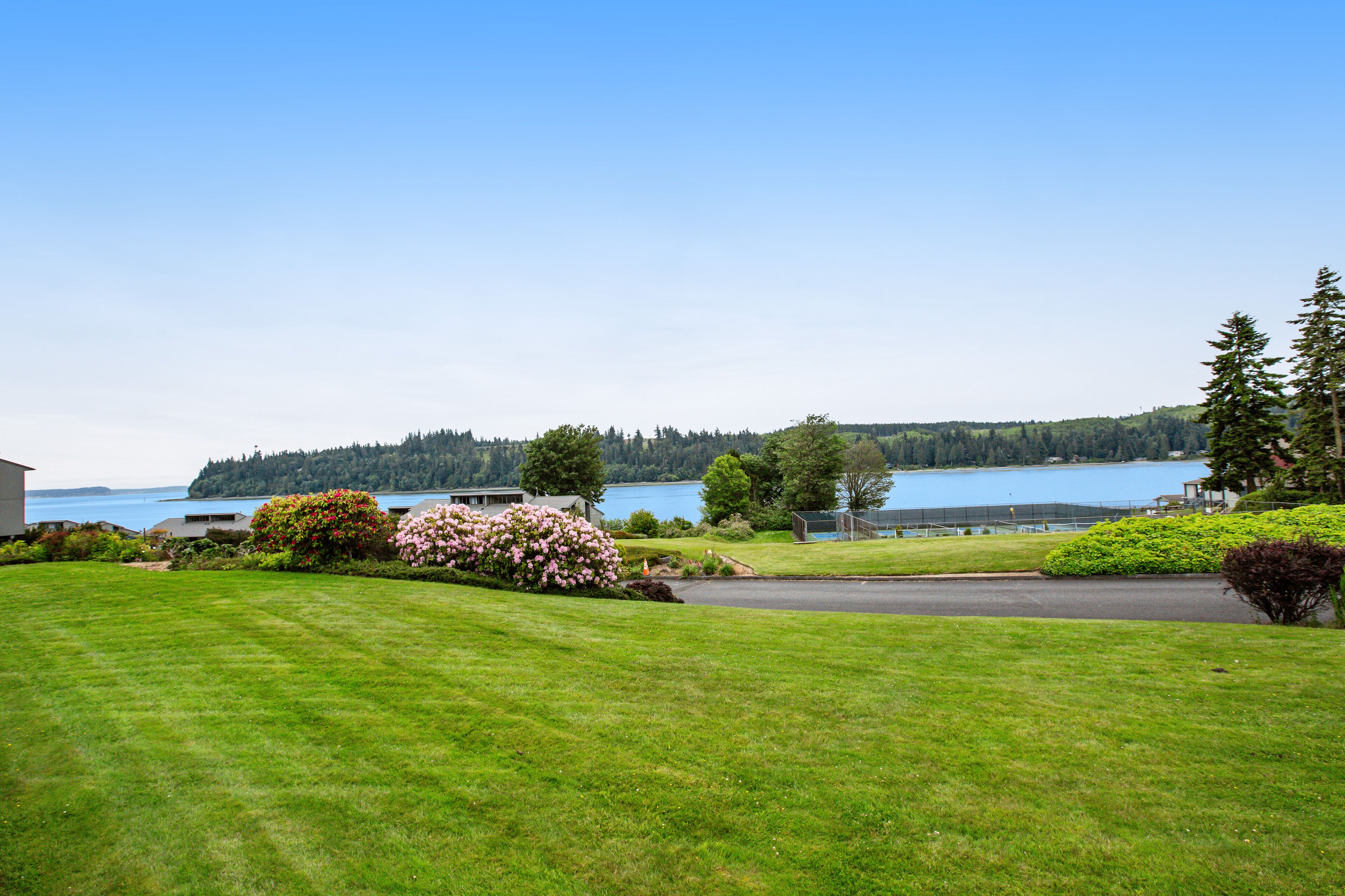 Water-view condo with deck, grill, yard games, resort pools, hot tub, and gym
