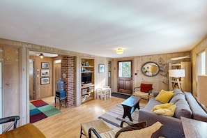 Relax in this inviting living room with a sofa set, coffee table, and TV, plus a dining area and cozy rug.