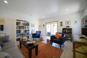 Relax in this inviting space with comfortable seating, a large bookshelf, and a TV for entertainment.