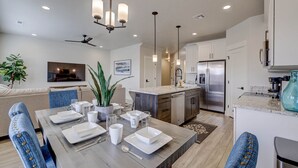 A modern kitchen with a central island, built-in appliances, and pendant lighting. - New Townhouse St George area, VidaSol (Washington)