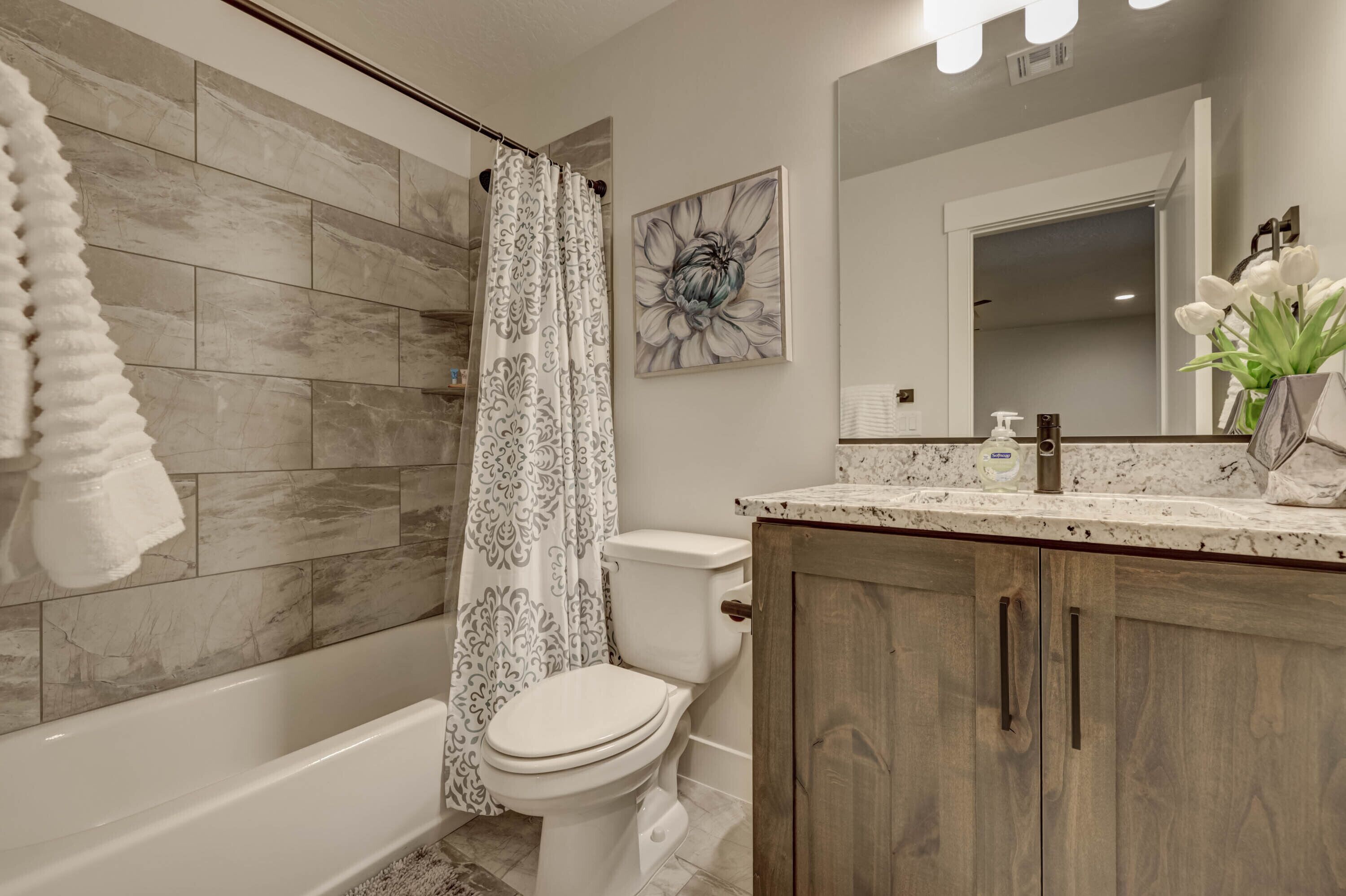 Une salle de bain équipée d’une douche, de toilettes et d’un meuble-lavabo avec un miroir.