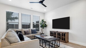 A living room with a sofa, coffee table, and TV. - New Townhouse St George area, VidaSol (Washington)