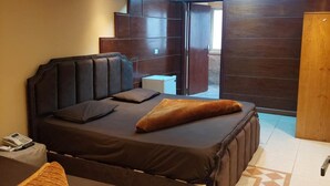 A modern bedroom with a large bed, a small bedside table, a telephone, and a skylight above the bed. - Blue Eyes Hotel (Giza)