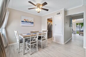 A modern kitchen with a built-in refrigerator, a ceiling fan, and a dining area with a table and chairs. - 2 bedroom Newly remodeled, walk to the Beach! Sleeps 6 (Fort Walton Beach)