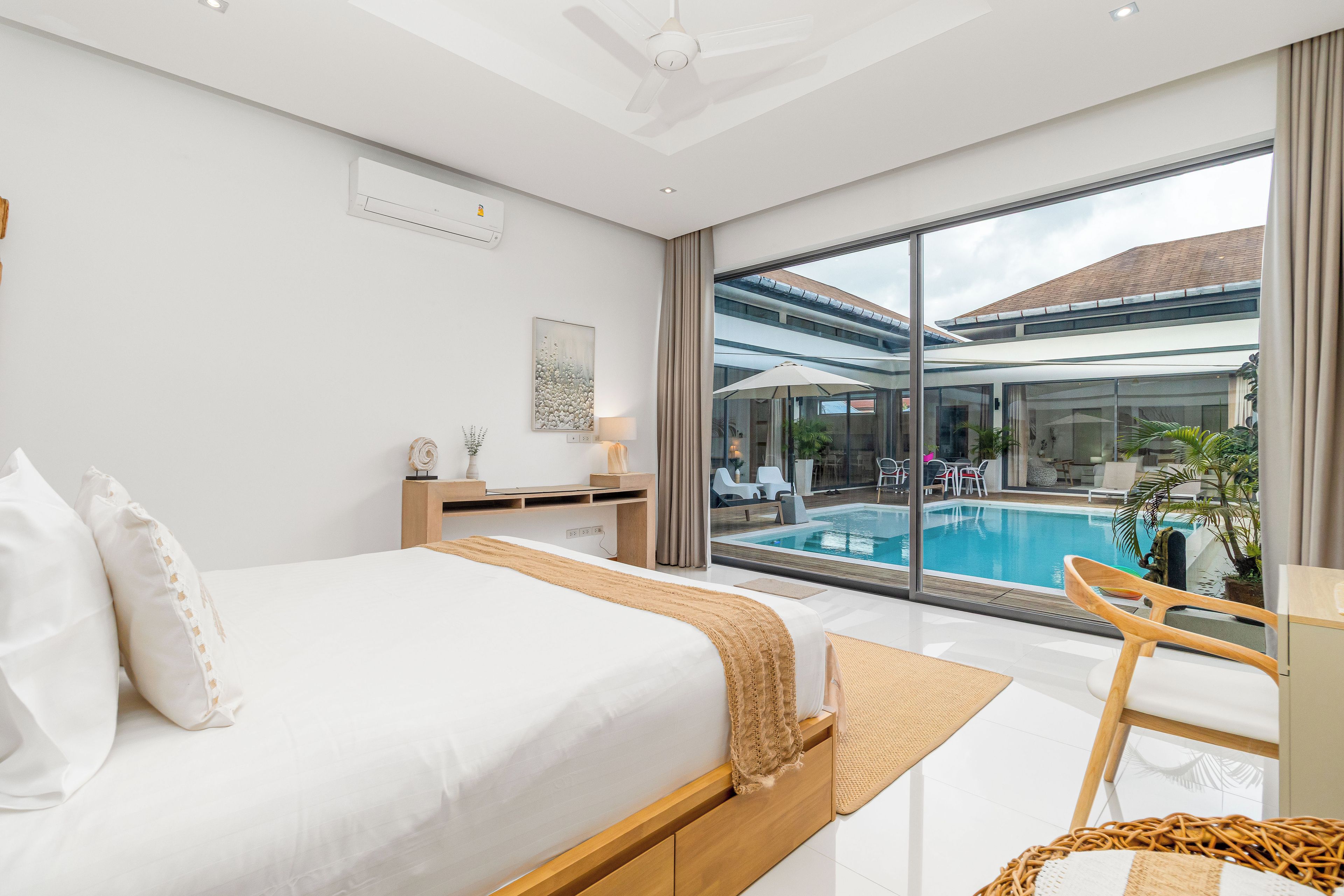 Une chambre d’hôtel moderne dotée d’un grand lit, d’un bureau, d’une vue sur une piscine et d’un balcon.