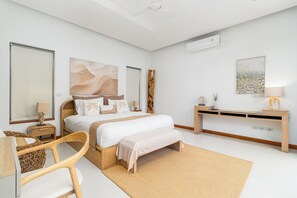 A modern bedroom with a bed, bedside tables, a desk, and a chair.
