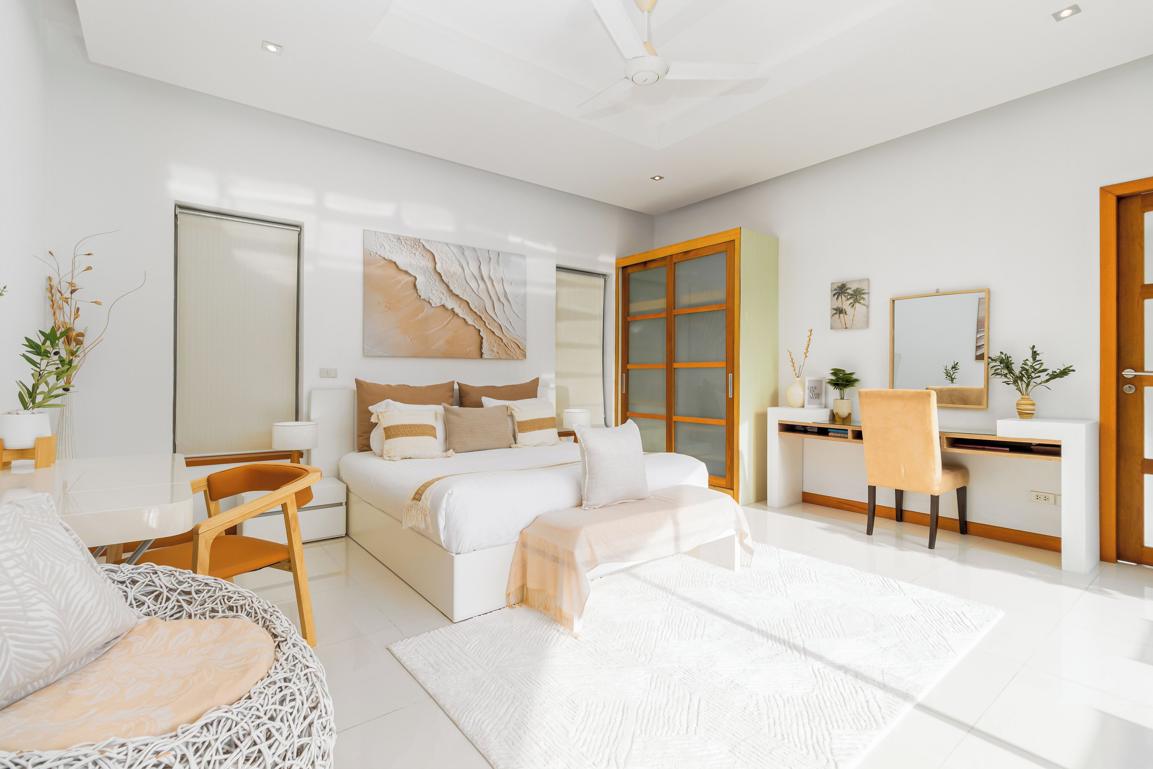 A modern bedroom with a large bed, a desk, and a chair.