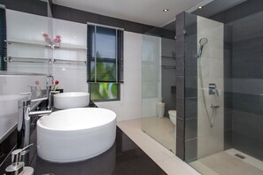 Een aparte badkuip en douche, een haardroger, handdoeken