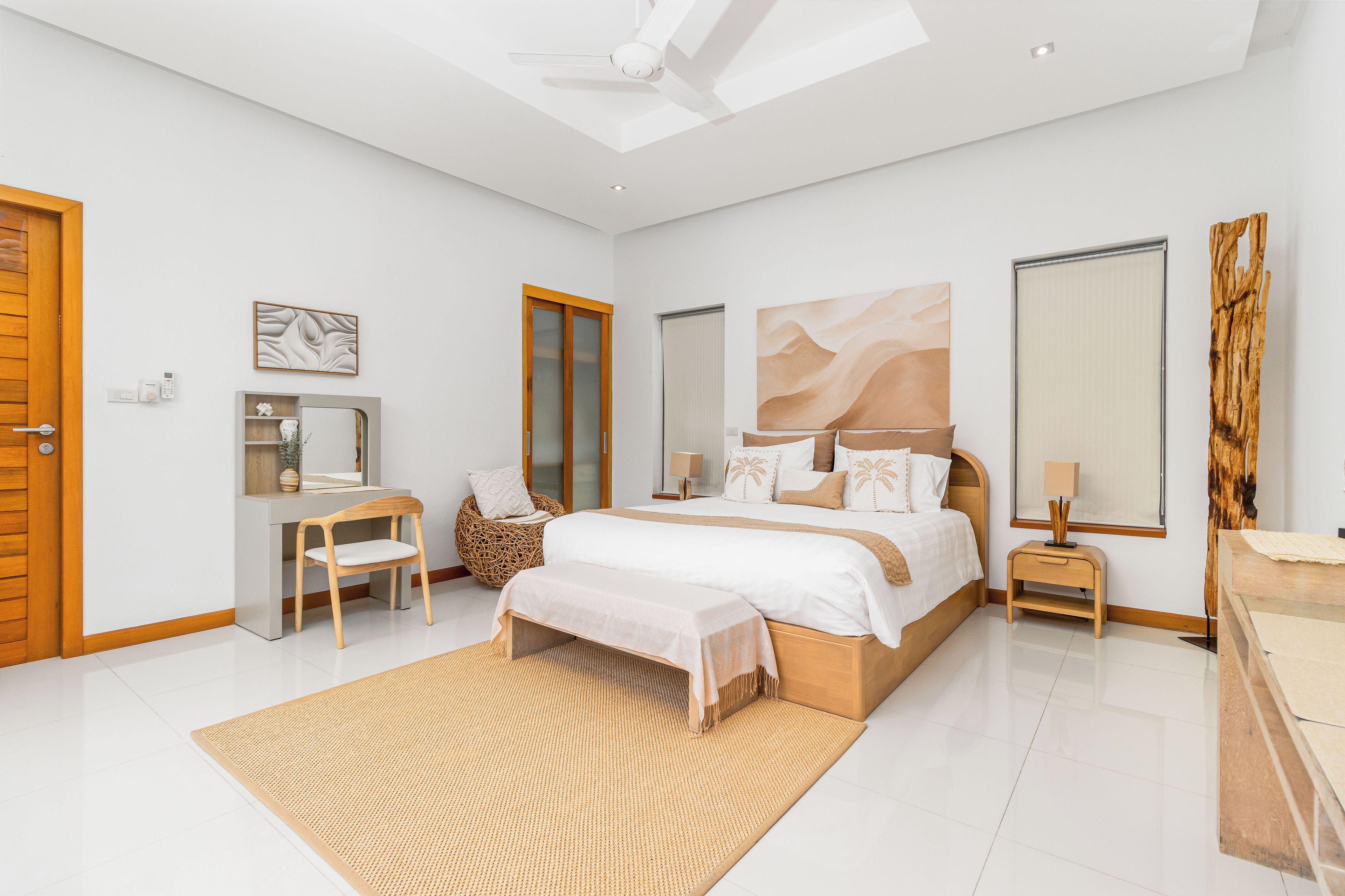 Un dormitorio moderno con cama, mesitas de noche, escritorio, silla y un espejo grande.