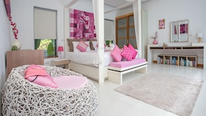 Ein Schlafzimmer mit Bett, Nachttisch, Stuhl, Bücherregal und Fenster.