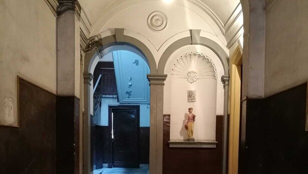A grand staircase with a marble floor leading to a door at the end.