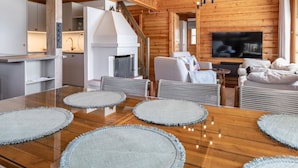 Interior moderno de una cabaña de troncos con comedor, cocina y sala de estar.