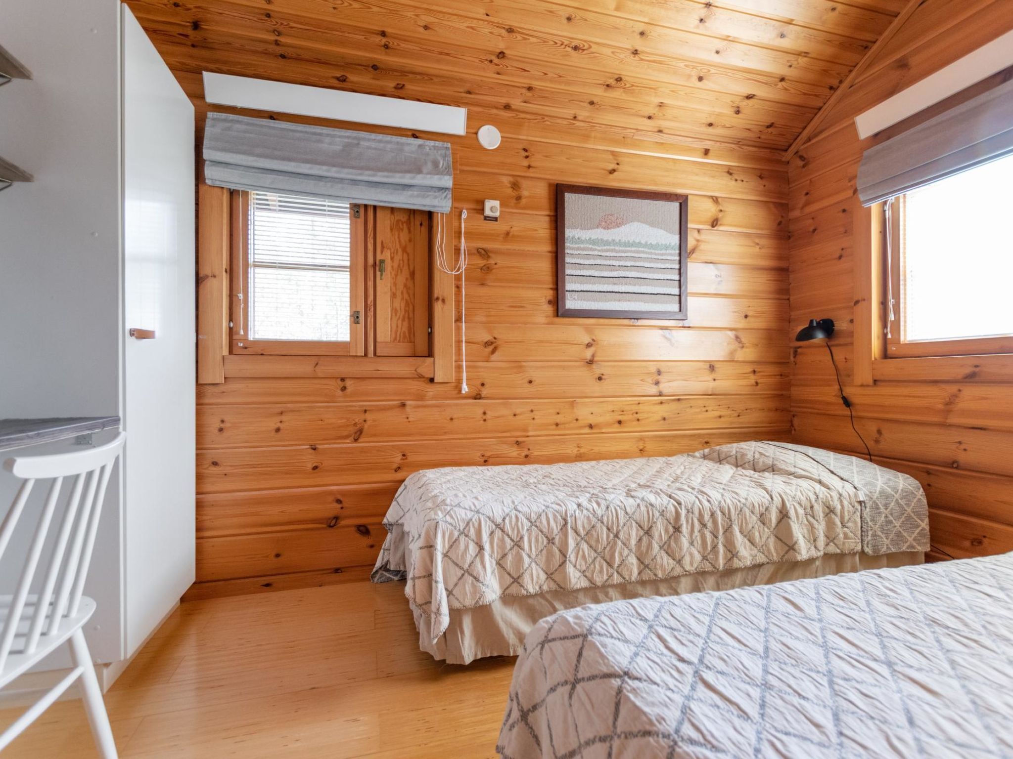 Een gezellig houten kamer met een bed voorzien van een geborduurde spreidek.