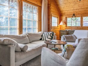 L'intérieur d'un chalet accueillant, avec un canapé, un fauteuil et une petite table.