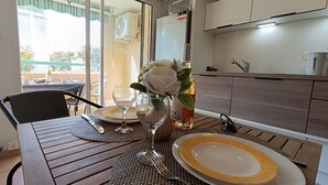Une table à manger dressée avec des assiettes, des couverts et un vase rempli de fleurs.