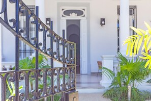 Enter a secure and elegant space with a grand entrance featuring intricate details and lush greenery.