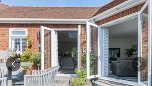 Una propiedad residencial con un patio, una mesa de comedor y asientos exteriores.