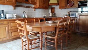 A kitchen with wooden cabinets, a tiled backsplash, and a central island with chairs.
