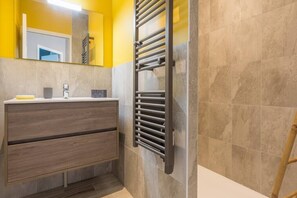 A modern bathroom with a wooden vanity, a towel rack, and a mirror. - Tribord, Apartment with Terrace and Ocean View, Parking Space (Saint-Côme-de-Fresné)