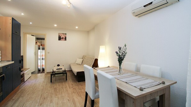 A compact living space with a dining area, a sofa, a lamp, and a wall-mounted air conditioner. - Apartment 2178/55780 (Istria - Pula), 3000m from the beach (Pula)